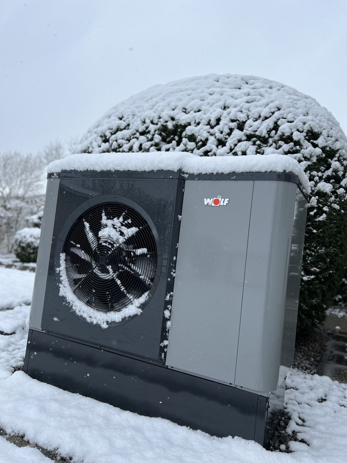 WOLF-Wärmepumpe mit Schnee auf dem Gehäuse